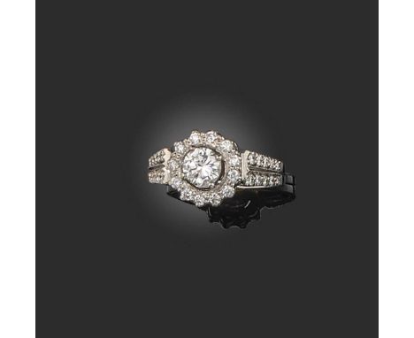 A diamond cluster ring, set with a central round brilliant-cut diamond within a surround of smaller diamonds and diamond shou