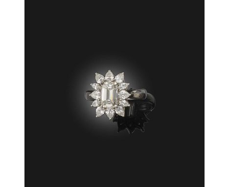 A diamond ring, of cluster design, set with a step-cut diamond weighing approximately 1.85 carats, within a border of pear-sh