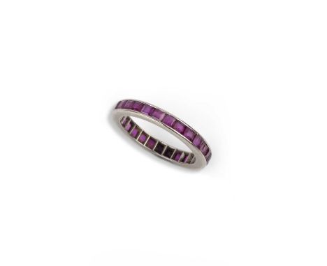 A ruby eternity ring, mid 20th century, channel-set with a continuous band of calibré-cut rubies, in white gold, size O