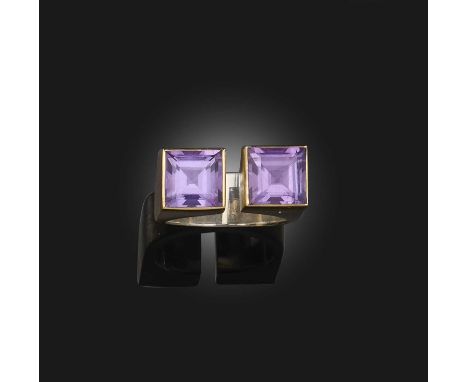 A modernist amethyst ring, of open U-shaped design, each end set with a step-cut amethyst, in a bicoloured silver mount with 