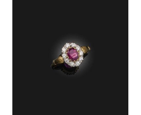 A ruby and diamond ring, claw-set with an oval ruby weighing 0.76 carats, within a border of brilliant-cut diamonds, mounted 