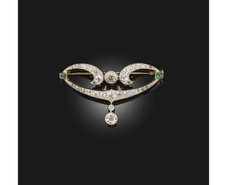 An Art Nouveau diamond and emerald brooch, circa 1900, of scrolled design suspending a pendant, set with circular- and rose-c