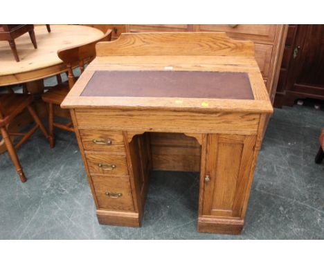 Light oak kneehole desk with raised back, leather writing surface, drawer and cupboard space