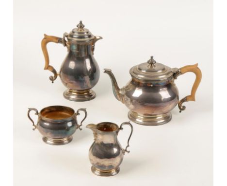 A FOUR PIECE TEA/COFFEE SET of oval form with stepped hinged lids, urn knopped finials, faceted spouts and wooden scroll hand