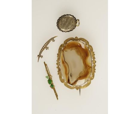 A 19TH CENTURY AGATE BROOCH, the large cabochon agate collet-set and surrounded by an open engraved scroll unmarked yellow go