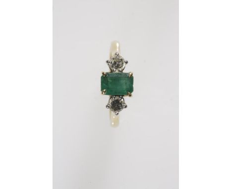 AN EMERALD AND DIAMOND THREE STONE RING, the central rectangular-cut emerald in a four claw cornet setting and flanked to eit