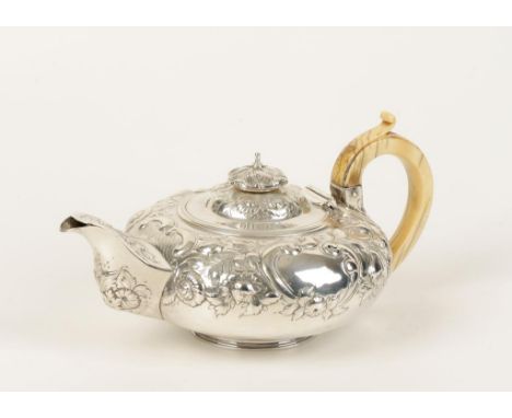 A GEORGE IV TEAPOT of compressed circular form with ivory scroll handle, the body embossed with foliate scrolls, possibly by 