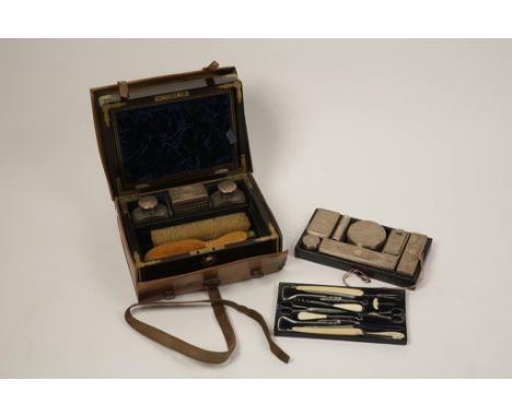 A VICTORIAN TRAVELLING VANITY SET, the brass bound coromandel case housing a number of silver mounted cut-glass jars and bott