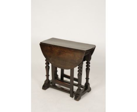 A NARROW OAK DROP FLAP GATELEG TABLE, the oval top with twin drop flap sides, on a frieze with four heavy turned baluster leg