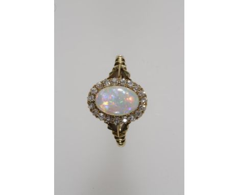 A VICTORIAN BLACK OPAL CABOCHON AND DIAMOND CLUSTER RING, the central oval opal c.9.4 x 6.3mm, surrounded by a millegrain-set