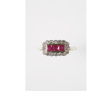 A RUBY AND DIAMOND CLUSTER RING, rub-over collet-set to the centre in a horizontal line with three princess-cut rubies and su