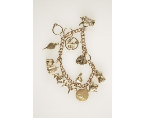 A 9CT ROSE GOLD CURB LINK BRACELET, each link hallmarked suspending twelve 9ct yellow gold and other charms including a Boxer