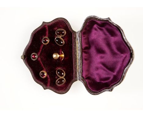 A SET OF VICTORIAN GARNET CABOCHONS CUFFLINKS AND DRESS STUDS, the cufflinks each set with an oval cabochon garnet within rop
