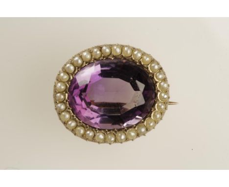 A 19TH CENTURY AMETHYST AND PEARL BROOCH set to the centre with an oval-cut amethyst surrounded by a rub-over half pearl set 