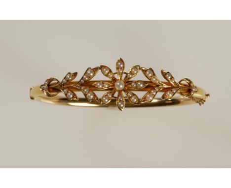 A VICTORIAN SEED PEARL BANGLE, hinged, the top section set overall with graduated pearls, forming a flower and leaf design, t