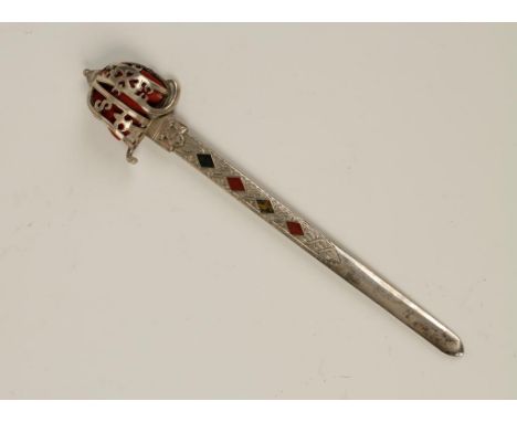 A VICTORIAN NOVELTY PAPER KNIFE modelled in the form of a sword, with a pierced scabbard, the blade inset with Scottish hards