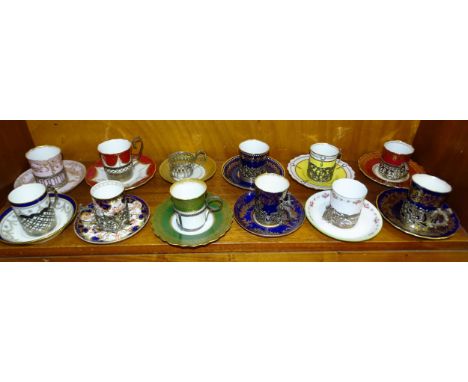 A collection of eleven ceramic coffee cans with pierced silver holders. 
