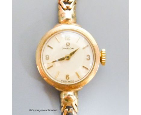   A lady's 9ct gold Omega manual wind wrist watch, on a 9ct gold bracelet, case diameter 20mm, gross 17.6 grams., with Omega 