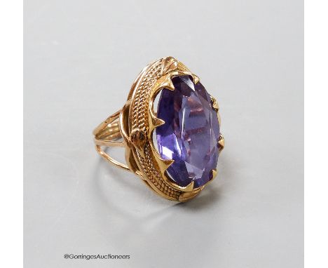   A yellow metal and synthetic colour change sapphire set oval dress ring, size O, gross 8.7 grams.