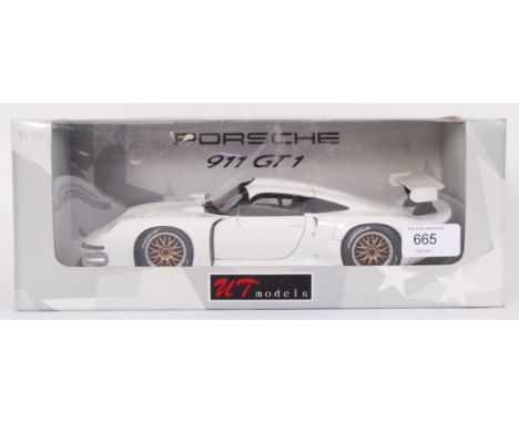 A UT Models 1:18 scale boxed diecast model Porsche 911 GT1. Mint, within the original box. In white, with gold coloured hubs.