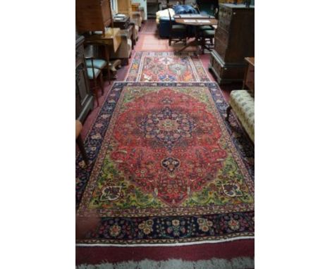 A PERSIAN TABRIZ CARPET, with centre medallion and all over floral pattern, with conforming lion floral spandrels, inside a d