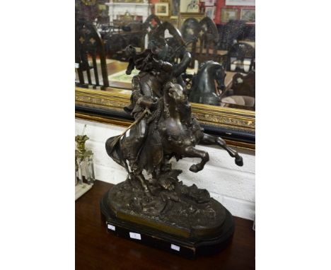 A BRONZED METAL EQUESTRIAN GROUP. Modelled with a cavalier with bugle and sword on horseback. Raised on moulded base. 24" (62