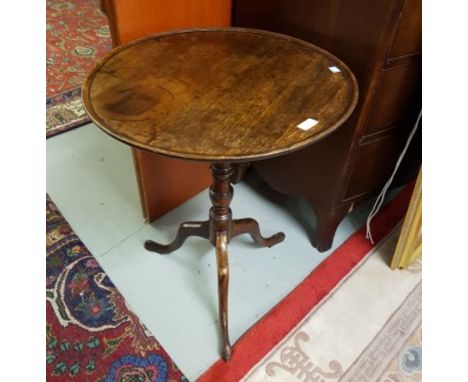 A NINETEENTH CENTURY CIRCULAR FLIP-TOP MAHOGANY CENTRE TABLE, with pie crust edge. On a turned stem and tripod base. 22" (56c