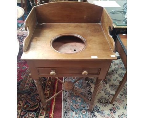 A WILLIAM IV PERIOD MAHOGANY WASH STAND. With three quarter shaped gallery and frieze drawer. Raised on spiral reeded taperin