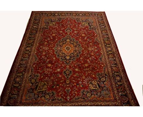 A BURGUNDY GROUND PERSIAN MASHAD CARPET, with all-over floral design, the centre medallion and conforming spandrels inside a 