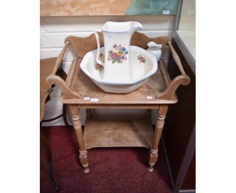 A VICTORIAN PINE WASH STAND, with arched back and a turned towel rail to either side, united by a stretcher shelf. 27" (69cm)