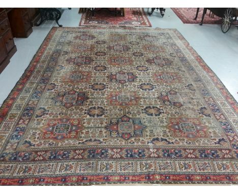 A LARGE ORIENTAL STYLE MACHINE-MADE CARPET. All-over stylised pattern, rows of medallions, inside a triple border. 13ft 8" (4