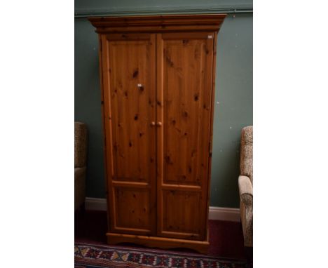 A MODERN PINE TWO DOOR WARDROBE, with moulded cornice on shaped bracket feet. 37" (94cm) wide. (1)