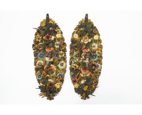 A pair of Continental wall sconces, each with a light fitting, the embossed metal backs painted with applied flowering branch