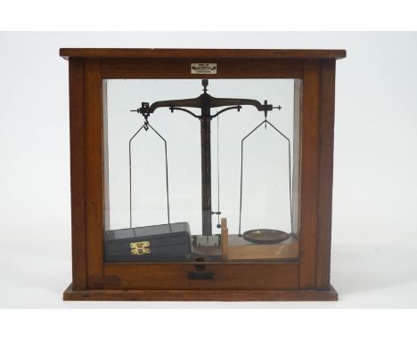 A wooden cased set of laboratory scales, of usual form and attendant weights, the case 37cm high x 41cm wide x 25cm deep
