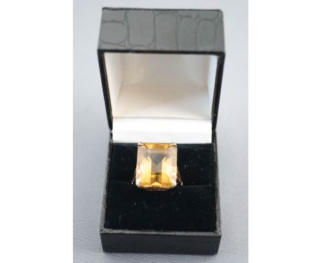 A yellow metal single stone ring. Set with a rectangular cut citrine quartz of approximately 24cts. Hallmarked 9ct gold, Lond