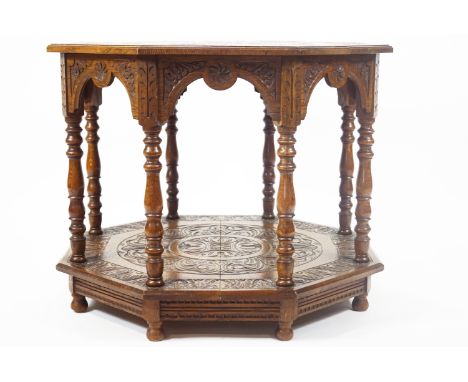 A late 19th century oak octagonal table, the top profusely chip carved with foliates and floral motifs, raised on an arcaded 