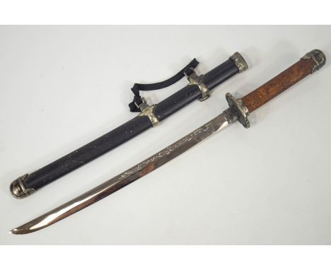 A replica Japanese short sword or Wakizashi with a carved wood metal capped handle with Tsuba on a blunt blade in a metal mou