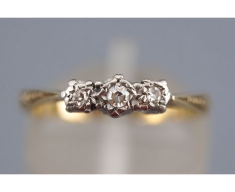 A yellow and white metal three stone diamond ring. Stamped 18ct Plat. Size: K ½ 2.4 grams