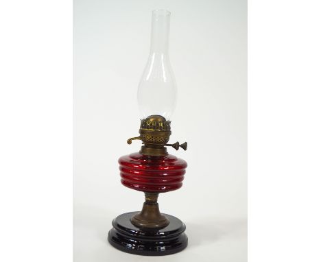 A Victorian oil lamp with ruby red glass reservoir, overall 51cm high