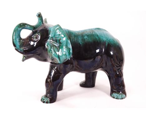 A large streaked turquoise glazed Poole pottery figure of a trumpeting elephant, 27cm high x 36cm wide
