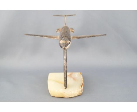 A desk paperweight in the form of a white metal finished model of a BAC 1/11 aircraft mounted on a polished top boulder edged