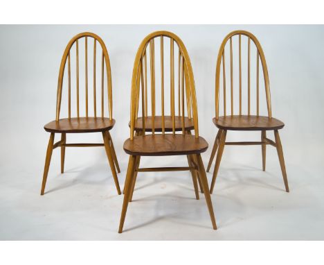 A set of four marked Ercol dining chairs with bentwood beech stick backs and stretchered legs, on shaped elm seats with origi