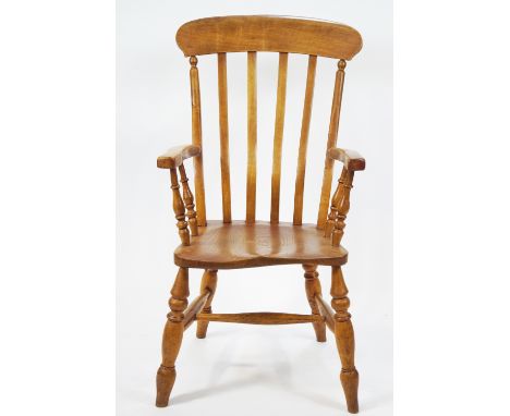 An elm and ash stick back elbow chair with solid seat and turned legs linked by stretchers