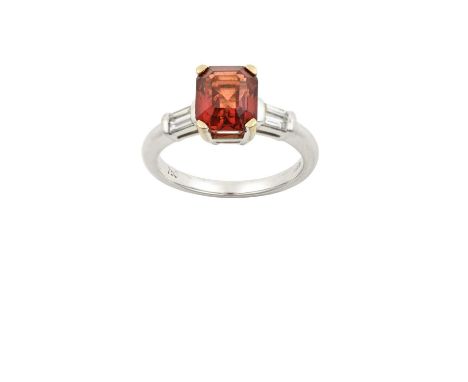 An 18 Carat White Gold Orange Sapphire and Diamond Ringthe emerald-cut orange sapphire in a claw setting, to baguette cut dia