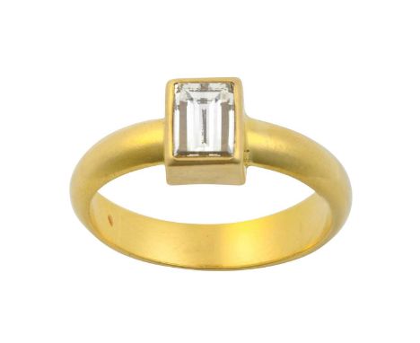 A Diamond Solitaire Ringthe fancy rectangular step-cut diamond in a yellow rubbed over setting, to a plain polished shank, es