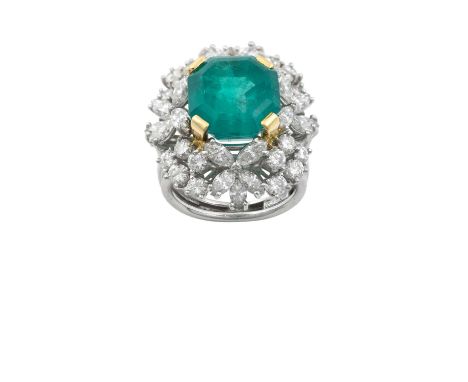 An Emerald and Diamond Cluster Ring the emerald-cut emerald in a yellow claw setting, within a border of round brilliant and 