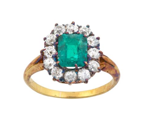 An Emerald and Diamond Cluster Ringthe emerald-cut emerald within a border of old cut diamonds, in yellow claw settings, to a