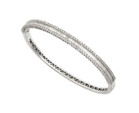 A Diamond Bangle the baguette cut diamonds between bands of round brilliant cut diamonds, in white claw settings, to a plain 