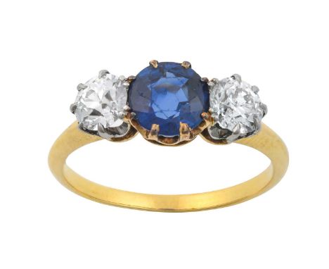 A Sapphire and Diamond Three Stone Ringthe round cut sapphire in a yellow claw setting, flanked by old cut diamonds in white 