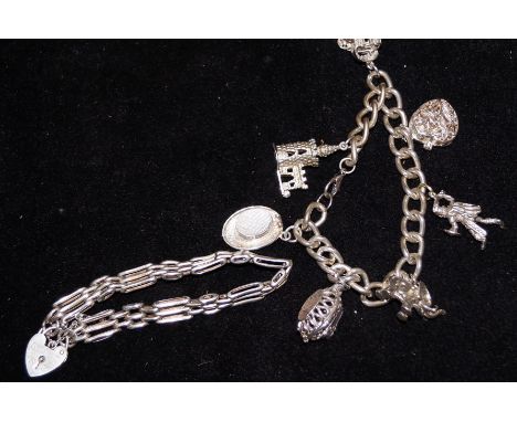 Silver charm bracelet with 7 charms together with a gate bracelet with heart shaped locket